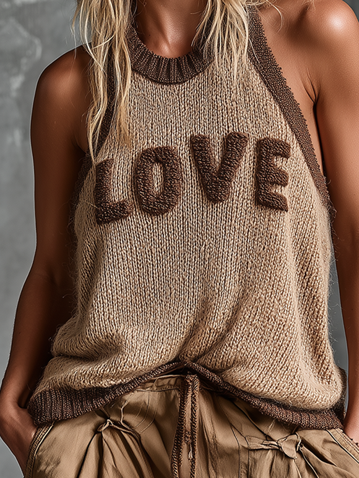 Person wearing a knitted tank top with 'LOVE' text on a neutral background