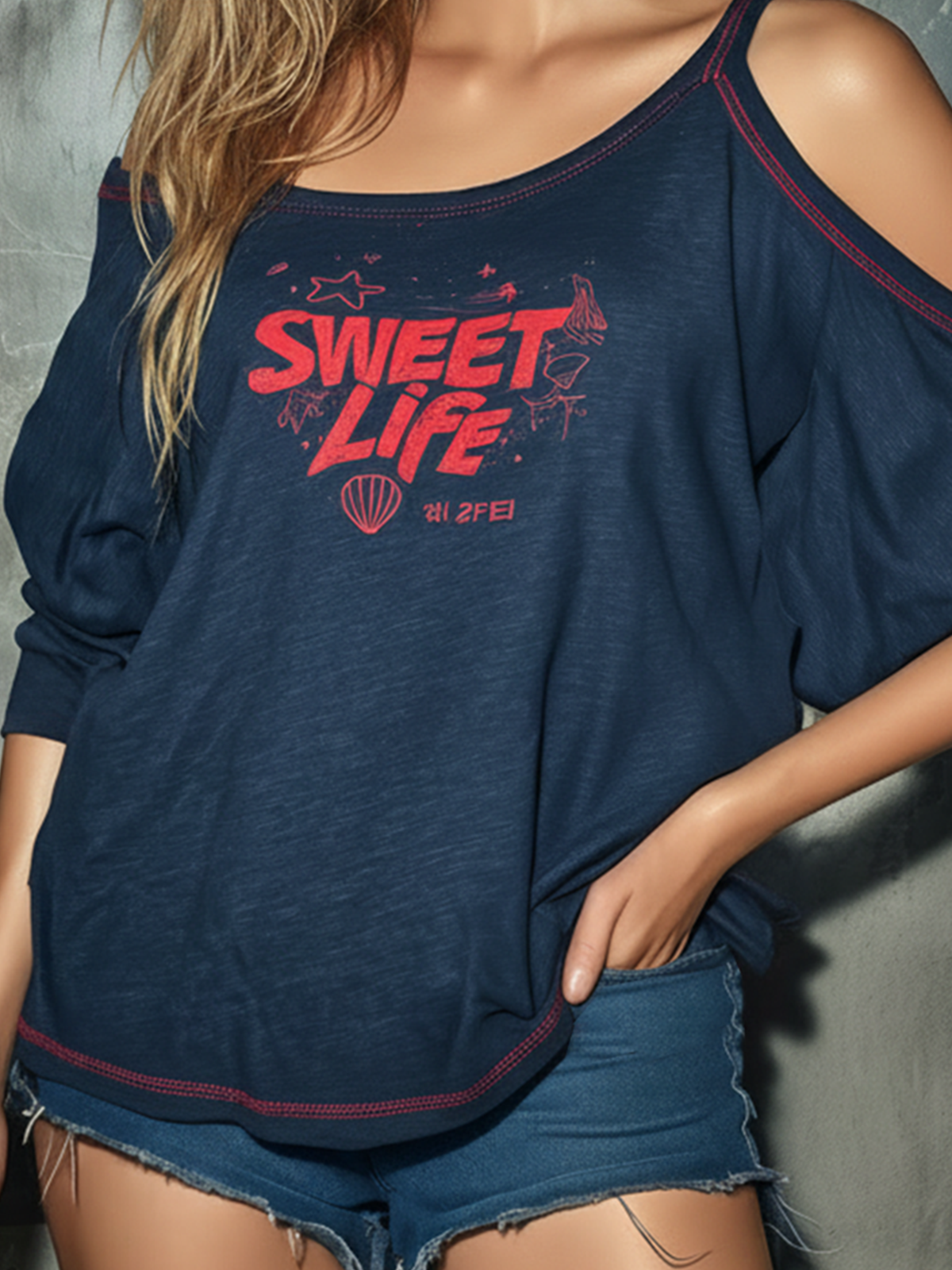 Person wearing a navy blue oversized shirt with 'Sweet Life' print and denim shorts against a gray background
