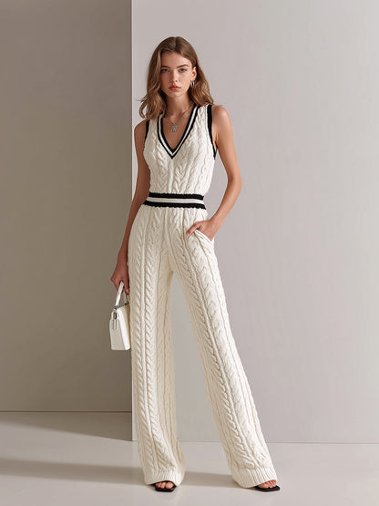 Woman wearing a white cable knit jumpsuit with black accents against a neutral background