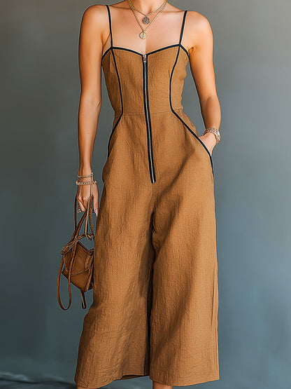 Woman wearing a brown jumpsuit with black accents against a gray background