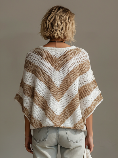 Person wearing a brown and white striped poncho against a plain background