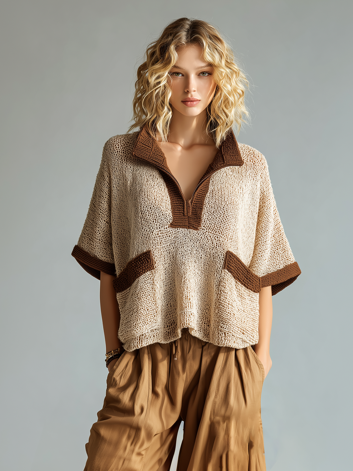 Woman wearing a beige and brown outfit against a plain background