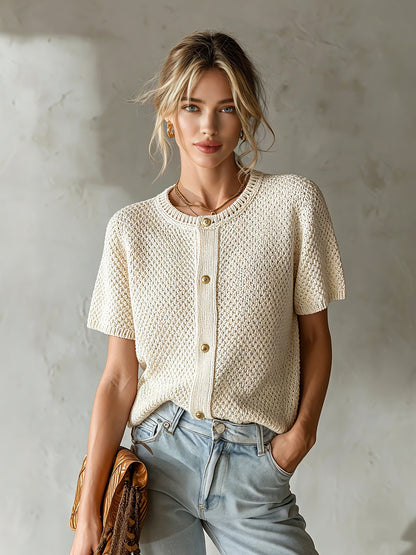 Woman wearing a beige knitted cardigan against a plain background