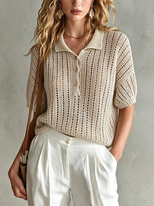 Woman wearing a beige knitted top and white pants against a neutral background