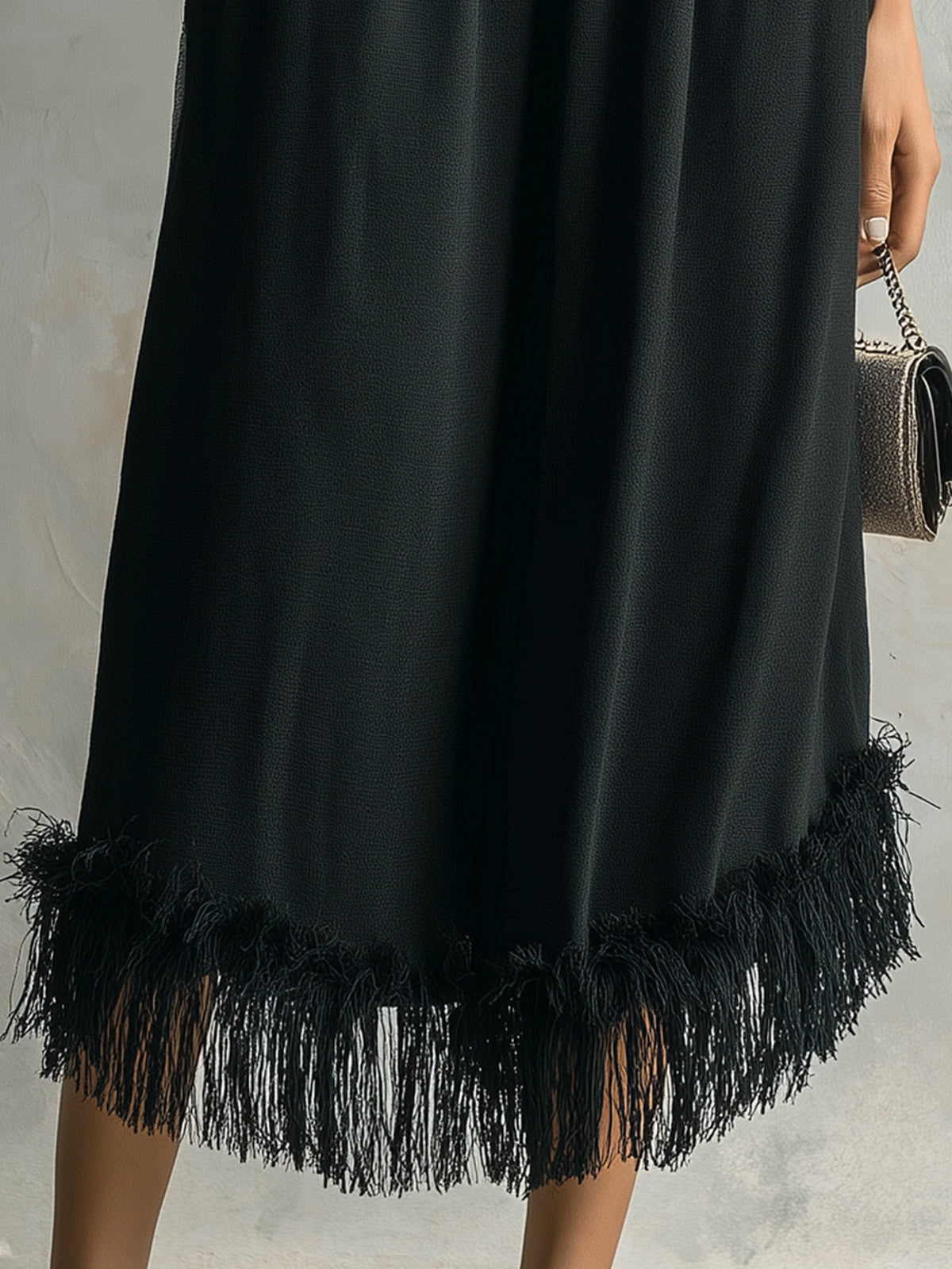 Black fringe dress on a neutral background