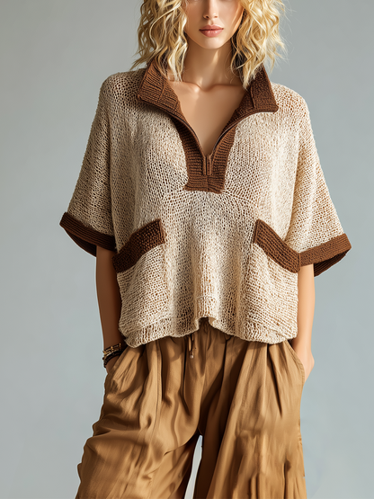 Woman wearing a beige knitted top with brown trim and matching pants on a gray background