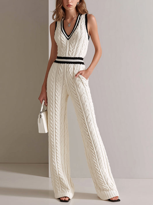 Woman wearing a white cable knit jumpsuit with black accents against a plain background